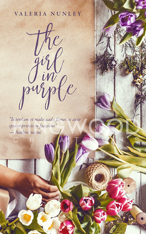 woman's hand holding flowers above table full of plants